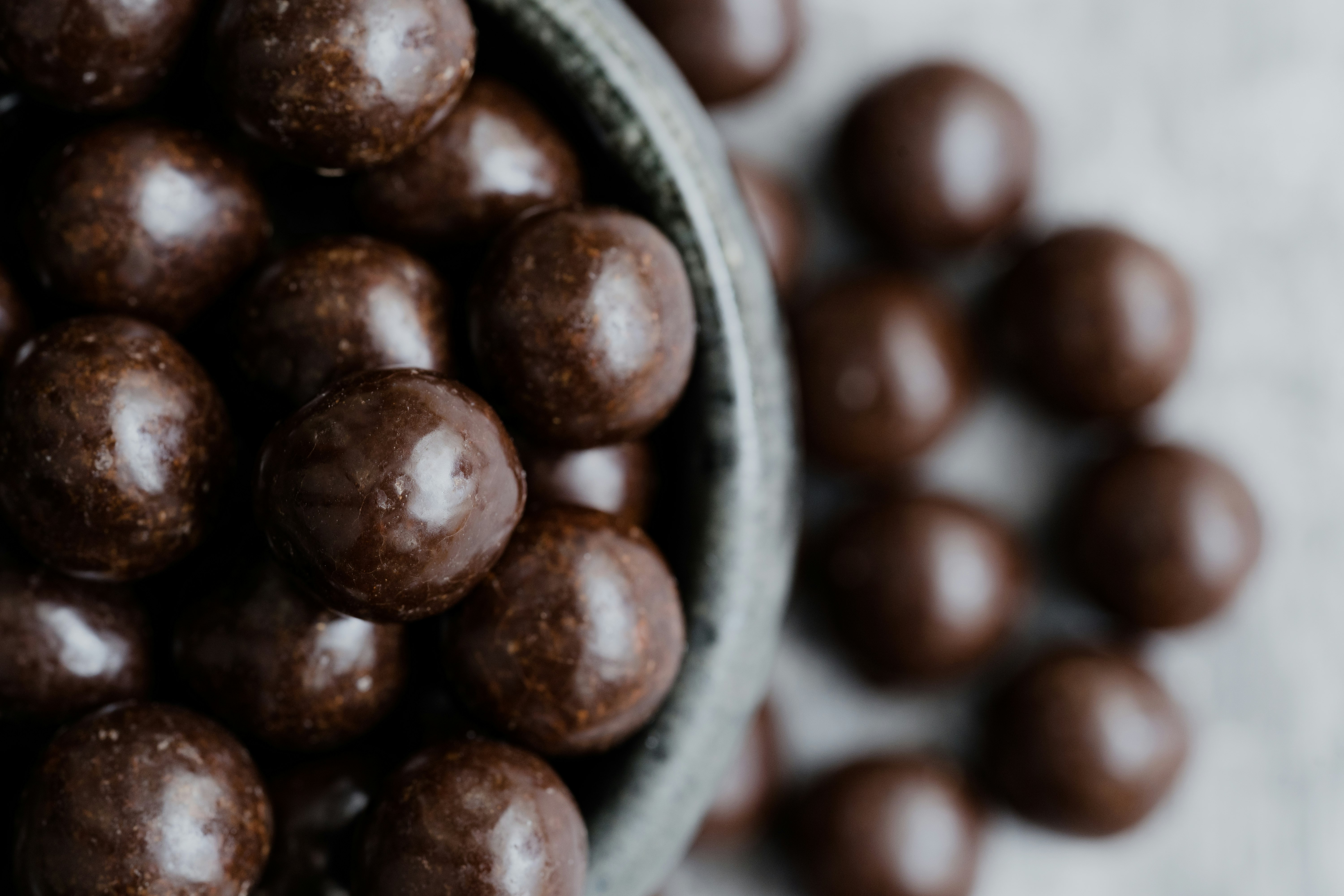 brown round fruit on green ceramic bowl